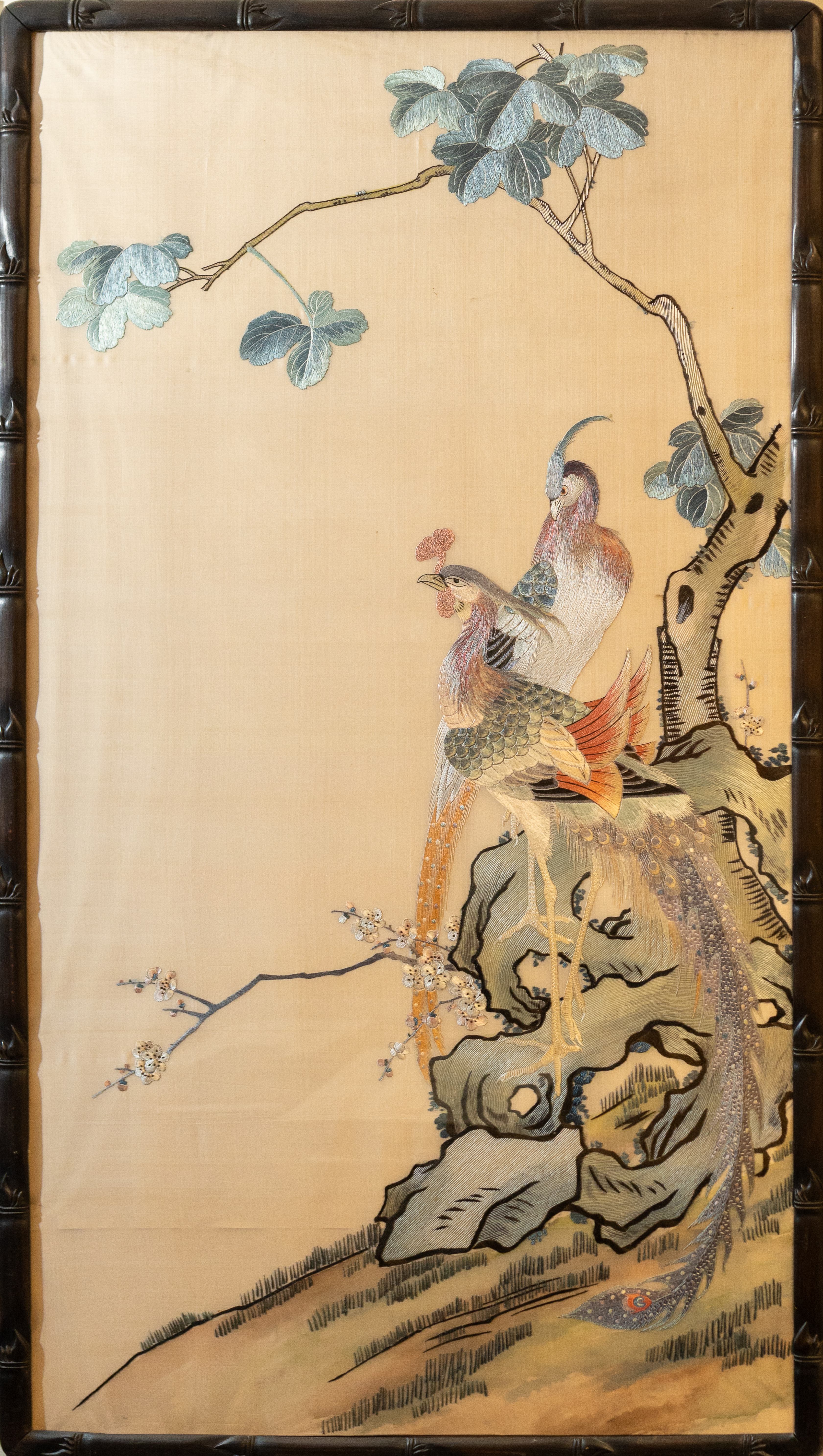 A Chinese painting with two embroidered images of colourful birds.