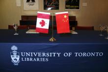 Photo of Canadia and Chinese flags on desk.